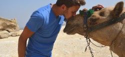 Travel writer and photographer Robert Schrader kissing a camel in Egypt