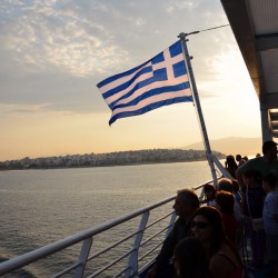 Greek Flag Behind Ferry in Greece