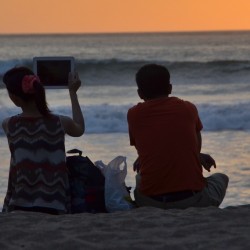 Woman Capturing Sunset With iPad