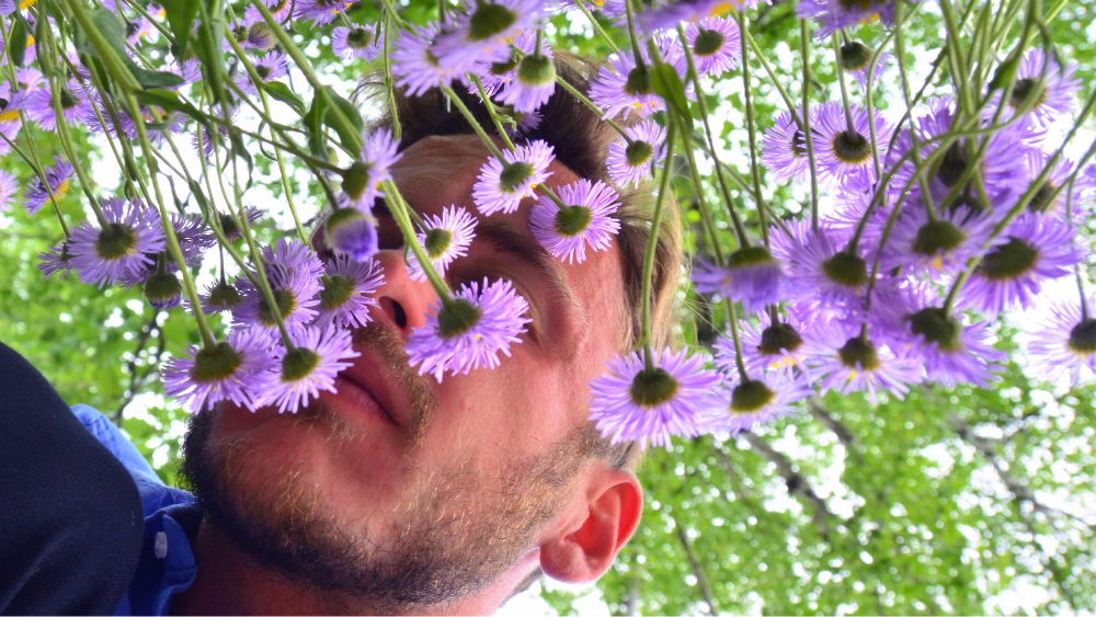Robert Schrader sniffing flowers