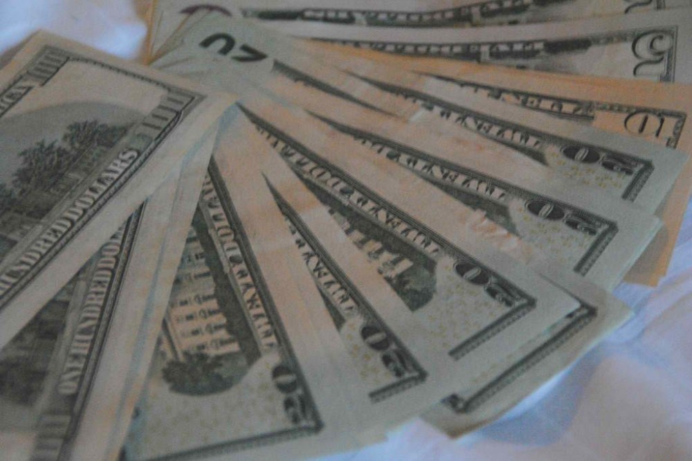 US dollars on a bed in Bangkok before a trip to Myanmar